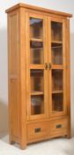 A good quality contemporary oak upright large display cabinet raised on squared legs having twin