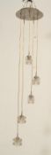 A contemporary pendant ceiling light fixture having five glass ice cube lights each at graduating