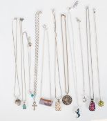 A selection of silver pendant necklaces to include a snake necklace with a wolf pendant medallion, a