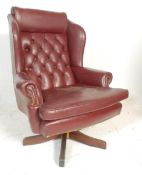 A vintage 20th Century Chesterfield style leather button back / wingback swivel armchair raised on