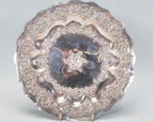 A Chinese silver card tray / dish, decorated in relief, scalloped border edge decorated throughout