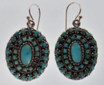 A pair of sterling silver oval earrings set with round and oval turquoise cabochons. Stamped