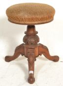 A Victorian 19th Century mahogany revolving piano stool raised on a splayed leg base having carved