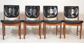 A set of four retro 20th Century teak wood framed dining chairs, black leatherette button back