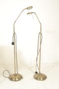 A pair of brass coloured vintage style free standing floor lamps raised on circular bases having
