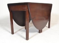 A 19th century Victorian mahogany drop leaf gate leg dining table being raised on squared legs