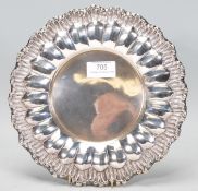 A 20th Century Portuguese silver plate of round form having reeded and scrolled decoration in high