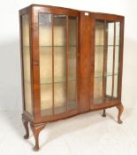 A 1930s  Queen Anne revival walnut serpentine-front display china cabinet, with two glazed doors,