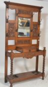 A late Victorian solid oak hall stand with central bevelled mirror flanked by carved panels, metal