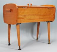 A vintage retro 1960's / 70's beech wood sewing box raised on four tapering legs with brass feet,