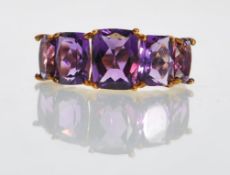 A 9ct gold hallmarked ladies dress ring set with five amethyst gemstones in a prong setting. Size P.