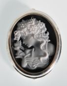 A silver Art Nouveau style cameo brooch depicting a young lady looking left with a fairy upon her