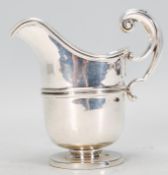 An early 20th Century Edwardian Martin and Hall silver hallmarked creamer jug raised on a round