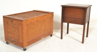 A mid century golden oak tambour top sewing cabinet box raised on castors together with another