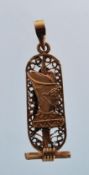 A Egyptian gold pendant of cartouche form having filigree inlay and Egyptian motifs to either