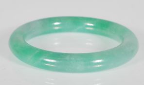 A Chinese green jade bangle of typical round form. Interior diameter 5.8cm. Weighs 65.1g.