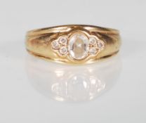 A 9ct yellow gold ladies ring set with a central white round faceted cut stone flanked by three