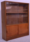 A retro 20th Century Herbert Gibbs teak wood sliding glass library bookcase cabinet having inset