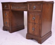 A mid century oak twin pedestal drop centre office desk. Each pedestal raised on plinth base with