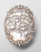 A vintage 20th Century silver hallmarked pill box / pot of oval form having repousse winged cherub