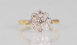 A hallmarked 18ct gold and diamond cluster ring set with nine round cut diamonds, one to centre with
