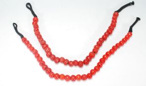 Two 20th Century red coral beaded necklace, each having large red beads on a string necklace, with