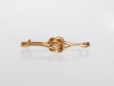 A 20th Century gold bar brooch with a knot design. Weight 2.3g. Measures 3.5 cm wide.