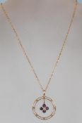 An early 20th Century 9ct gold open work pendant necklace, the pendant of circular form with a