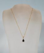 A 9ct gold and sapphire necklace and pendant. The 9ct fancy link chain adorned with a blue