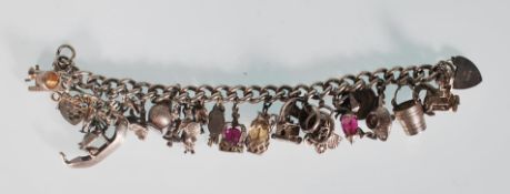 An English silver hallmarked charm bracelet having a curb link chain with 25 charms to include a