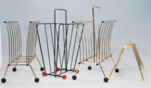 A group of four 20th Century retro record racks / magazine racks of metal tubular construction.