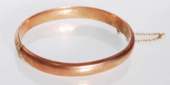 An early 20th Century hallmarked 9ct gold bangle bracelet having engraved scrolled foliate
