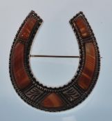 A ladies silver and agate brooch in the form of a horse shoe. Stamped sterling silver. Measures 3.