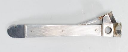 A good silver hallmarked cigar cutter of lung rectangular form having engine turned decoration and