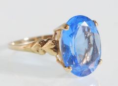A hallmarked 9ct gold ladies dress ring prong set with an oval cut blue stone having heart