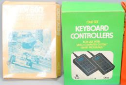 A collection of vintage original Atari handheld video games and keyboard controllers including