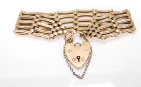 A hallmarked 9ct gold gate link bracelet having a heart lock clasp and safety chain. Hallmarked
