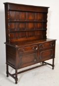 A 1920's oak Jacobean revival geometric block fronted sideboard / dresser. Raised on bobbin turned