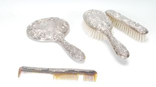 A Victorian silver hallmarked ladies dressing table set in a rococo design comprising hand held