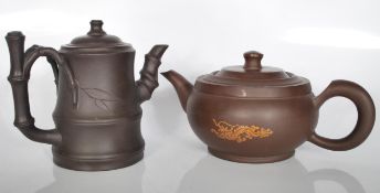 A pair of 20th century Chinese Yi Xing terracotta teapots. One of the teapots has a bamboo design on