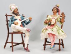 A pair of 20th Century ceramic continental creole band figures seated upon bamboo chairs playing