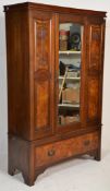 An Edwardian Art Nouveau walnut wardrobe having a