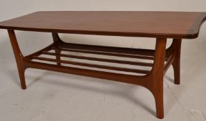 A 20th Century retro vintage teak wood coffee table having a shaped top and magazine rack bellow,