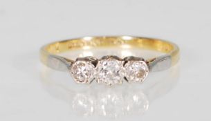 An 18k yellow gold and platinum mounted three stone diamond ring set with round cut diamonds of
