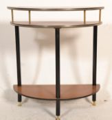 A retro 20th Century three tier demi lune hall table raised on three ebonised supports with brass
