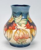 A Moorcroft vase of globular form in the Anna Lilly pattern. Tubelined on a blue and cream ground.
