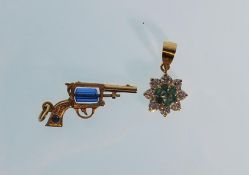 A good 9ct yellow gold pendant in the form of a revolver having a faceted cut glass revolving centre