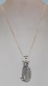 A ladies silver pendant necklace featuring a sitting stylized cat decorated with an Art Deco design.