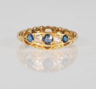 An early 20th Century 18ct gold ring set with three round cut sapphires and two round cut diamonds