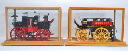 Two good quality glass cased models of horse drawn stagecoach / carriages. Both having coach lights,